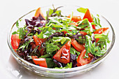 Mixed leaf salad with tomatoes on a glass plate