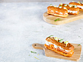 Savoury eclairs with salmon and ricotta on wooden boards