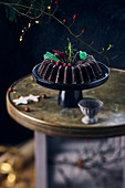 A chocolate Bundt cake with winter decorations on a cake stand