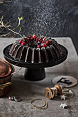 Winterlich dekorierter Schokoladen-Gugelhupf auf Kuchenständer