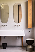 Organically formed mirrors above sink on cabinet legs