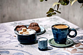 Cup of turkish black coffee with milk, sugar cubes and cookies