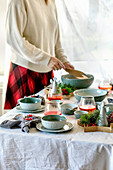 Rustic Christmas table setting with craft ceramic tableware, plates and bowls