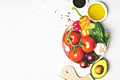 Olive oil, vinegar, vegetables and spices on white background