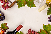 Weinflaschen mit Gläsern, Trauben, Blättern und Korkenzieher