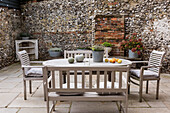 Garden furniture on the terrace in front of a rustic stone wall