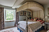 Antique four-poster bed in English-style bedroom