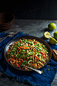 Vegan crunchy quinoa salad with carrot, peppers, coriander, limes, sesame seeds, sesame oil and penut butter dressing