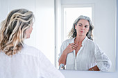 Woman looking at herself in a mirror