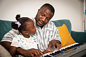 Father and daughter playing keyboard