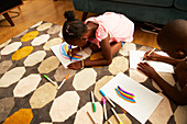 Girl drawing multicolour rainbow with markers