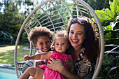 Portrait mother and daughters in summer swing chair