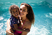 Portrait mother and daughter in summer swimming pool