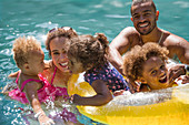 Portrait happy family playing in summer swimming pool