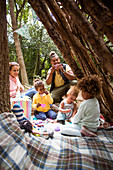 Family playing tea party in tree fort
