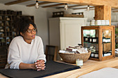 Thoughtful female shop owner behind counter