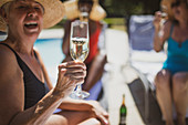 Senior woman drinking champagne with friends