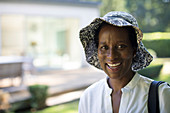 Portrait mature woman in sun hat in summer backyard