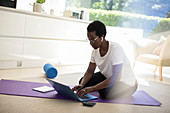 Woman working and exercising on yoga mat at home