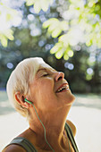 Happy senior woman listening to music with headphones