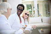 Senior women friends in sunglasses and spa robes