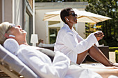Senior women in spa robes relaxing on hotel patio