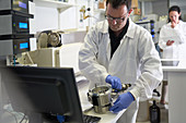 Male scientist using equipment at computer in laboratory