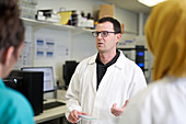 Male scientist talking with colleagues in laboratory