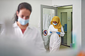 Scientist in face mask and hijab using digital tablet