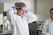 Scientist putting on protective hair net