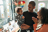 Happy parents with baby daughter at home