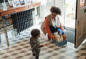 Mother and baby daughter receiving grocery delivery