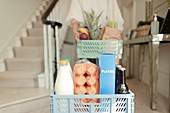 Woman receiving grocery delivery in foyer
