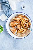 Fish and chips - fried cod, french fries, green peas and tatar sauce