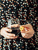 Frau hält Glas Rotwein und Tarallini