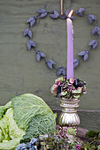 Candle with a wreath of hydrangea blossoms in a silver candlestick