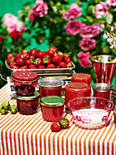 Selbstgemachte Erdbeermarmelade in Gläsern auf Gartentisch