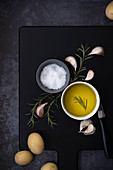 Olive oil, salt flakes, rosemary and potatoes