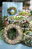 Autumn wreaths made of moss and hydrangea blossoms, Brussels sprouts, and onions as decoration