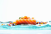 Raw salmon fillet decorated with flowers and caviar