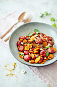 Beetroot gnocchi with curry, carrots, cashews and goji berries