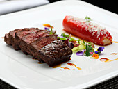 Roasted Beef steak with stuffed pepper, herbs and flowers