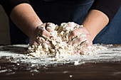 Kneading bread dough on table with flour