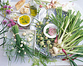 Chives with red and white blossoms, spring onions, young garlic, garlic buds and olive oil
