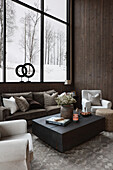Couchtisch im Wohnzimmer in Naturfarben mit Blick auf Schneelandschaft