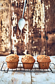 Spoon pouring topping on muffins