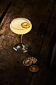Gelber Zitrus-Cocktail mit getrockneter Orangenscheibe