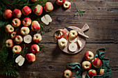 Ganze und geschnittene rote Äpfel auf Schneidebrett mit Messer