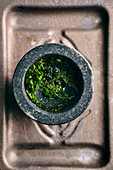 Fresh herbs and spices for chimichurri in a mortar