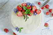 Yoghurt cake with tonka bean, strawberries and flower decoration